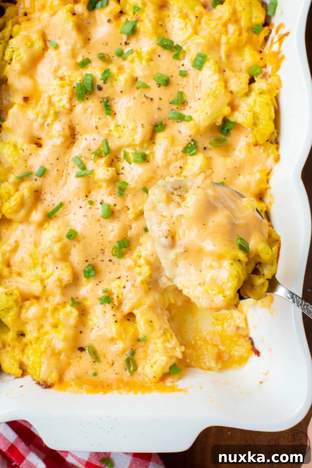 sausage breakfast casserole with hash brown, scrambled eggs, bacon, ham, and creamy cheese sauce, a hearty and delicious make-ahead meal