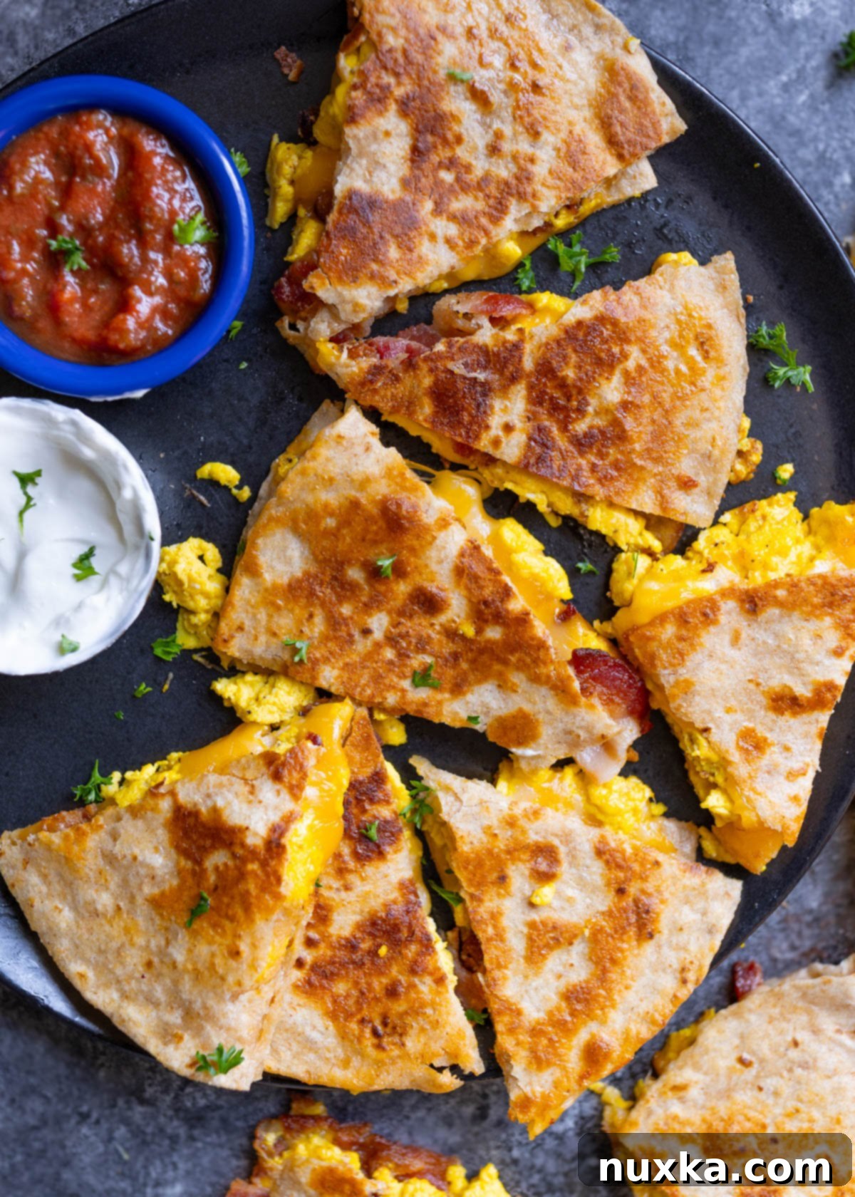 healthy breakfast quesadillas using whole wheat flour tortillas, bacon with no nitrates, free-range eggs, and freshly grated cheese served with homemade salsa and Crema