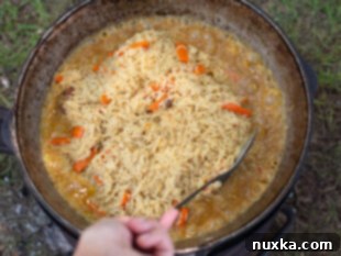 Adding rice to the Plov in a Kazan