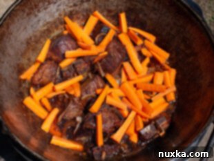 Adding carrots to the Zervak for Uzbek Plov