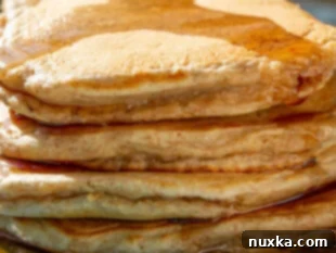 stack of whole wheat pancakes with maple syrup
