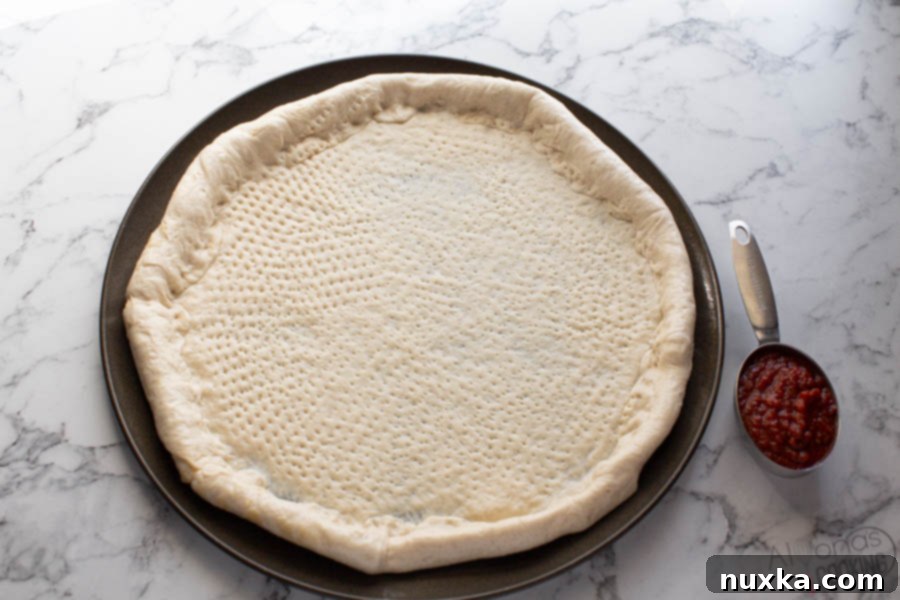 Demonstration of how to use a docker wheel on pizza dough