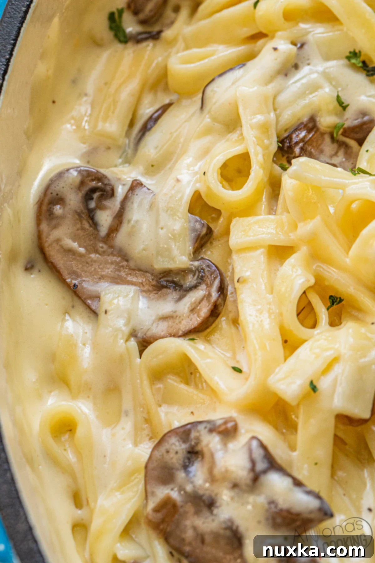 the most creamy Alfredo sauce recipe ever! A close-up of pasta generously coated in a rich, white Alfredo sauce.