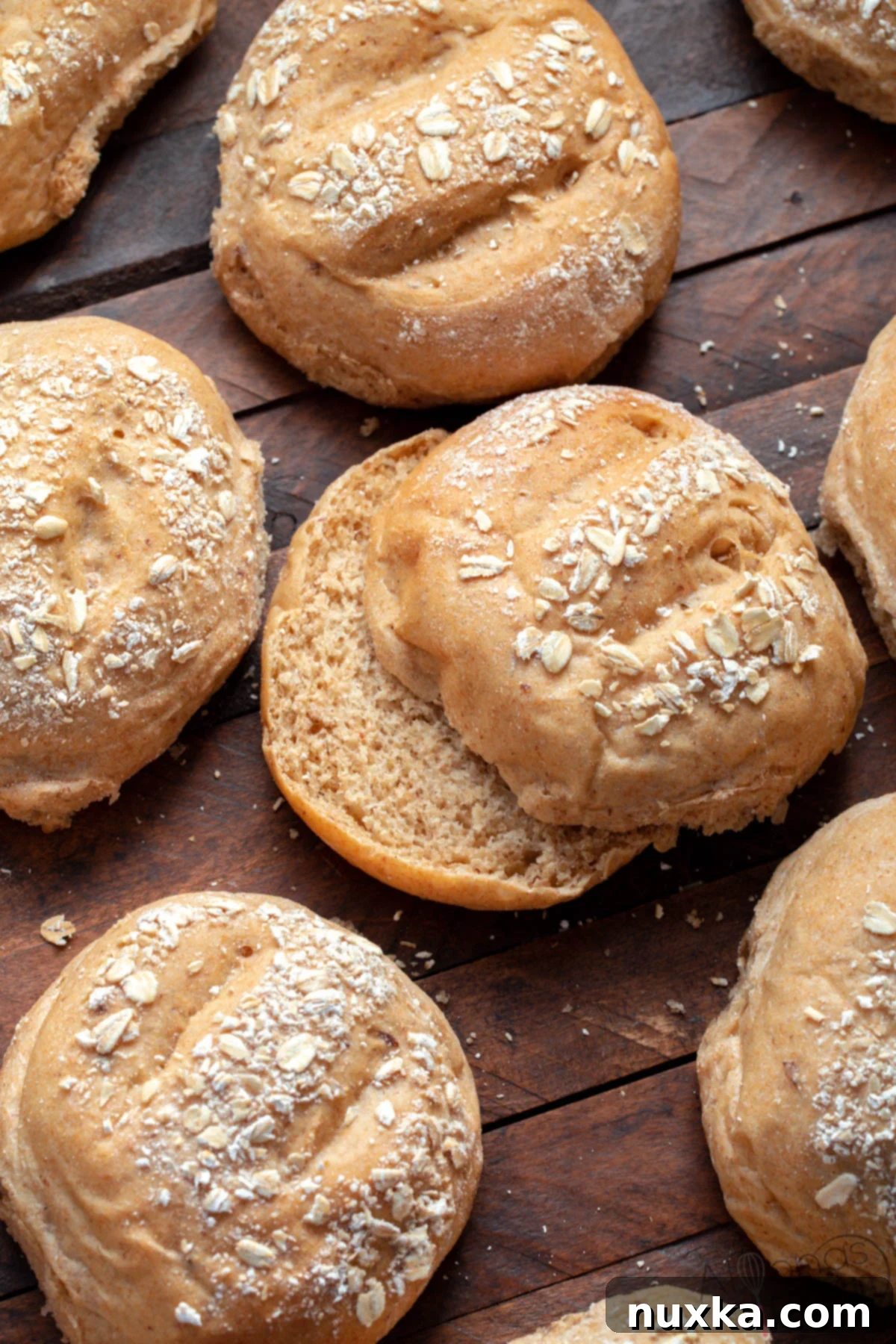 Soft and fluffy homemade whole wheat hamburger buns with a multigrain oat topping, replicating the Chick-fil-A multigrain brioche bun, arranged on a baking sheet.