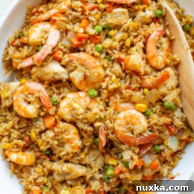 Ultimate Shrimp Fried Rice 2 Image of a perfectly cooked homemade shrimp fried rice with chicken, vegetables, and eggs in a white bowl.