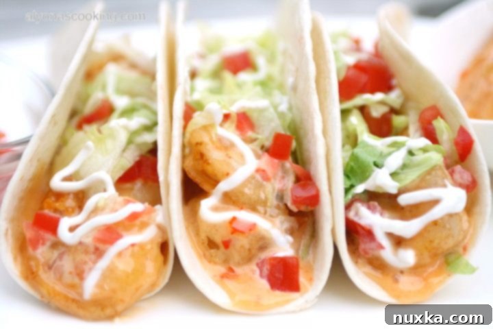 Delicious Bang Bang Shrimp Tacos with crispy shrimp, fresh lettuce, and tomatoes, a Bonefish Grill copycat recipe.
