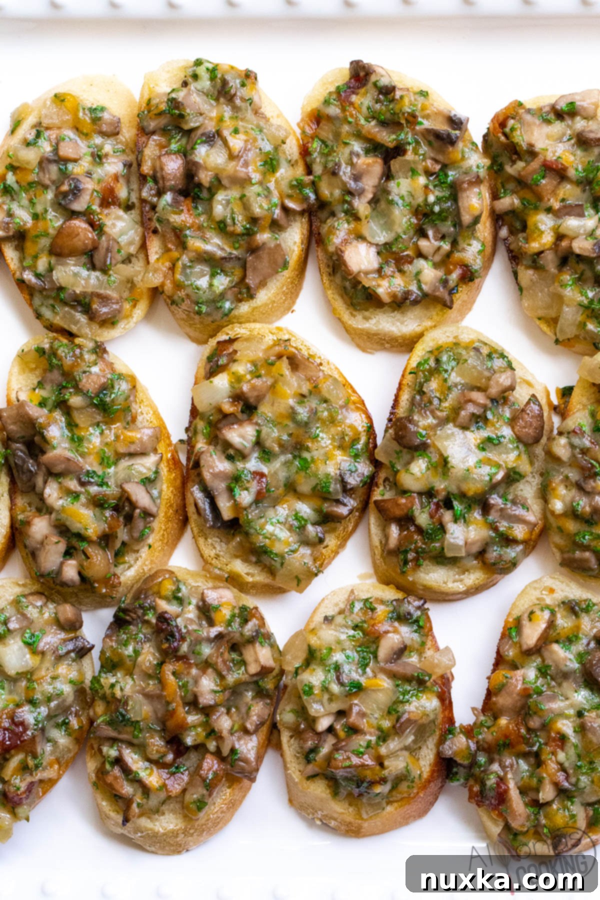 Platter of golden brown hot mushroom canapés with melted cheese, ready to serve at a party.