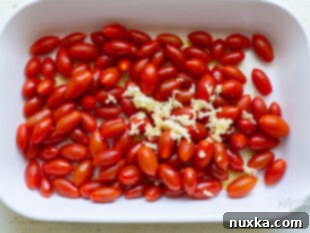 baked feta pasta prep: cherry tomatoes, olive oil, and spices in a baking dish