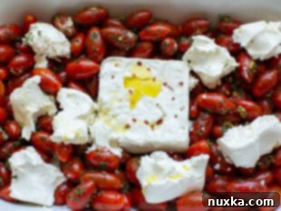 baked feta pasta with feta cheese in the middle and cream cheese chunks surrounding it