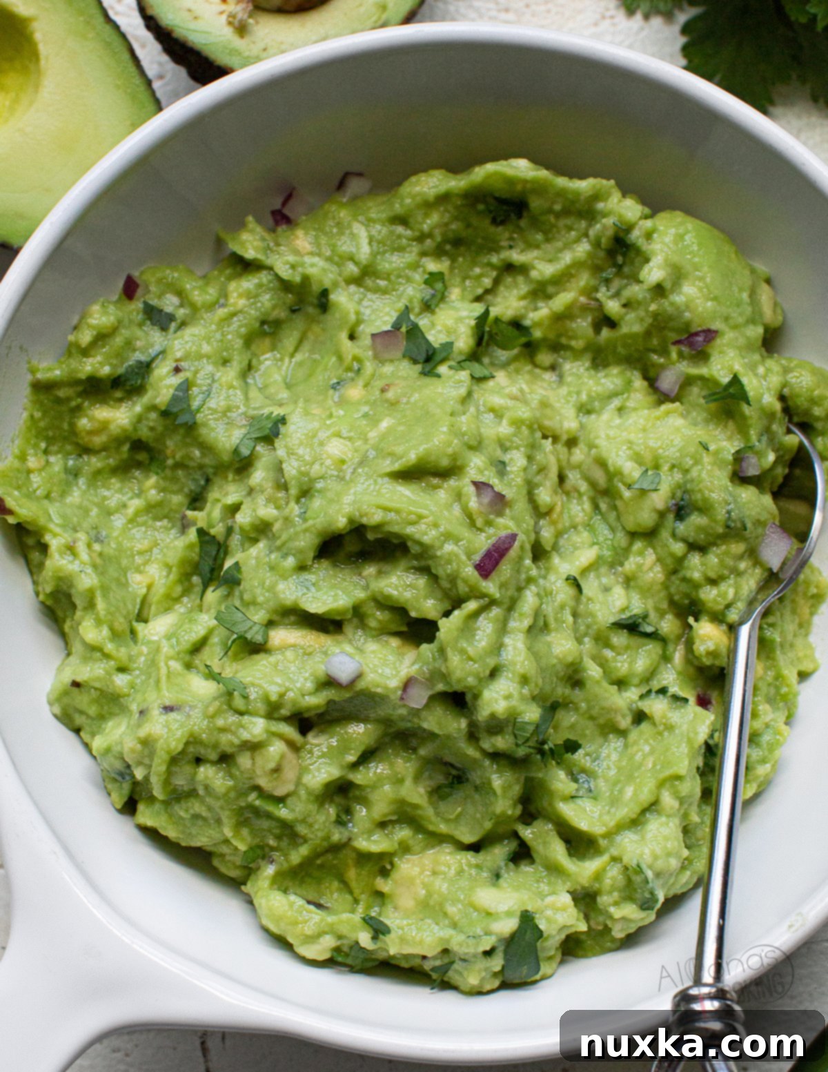 Chipotle guacamole recipe, featuring creamy avocado, fresh cilantro, jalapeno, lemon, lime, purple onion, and salt, just like the restaurant's famous dip. Served with tortilla chips.