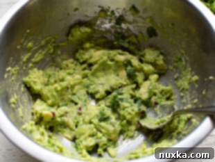 Mix all guacamole ingredients together with a rubber spatula.