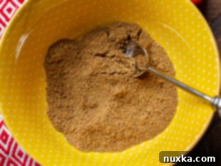 Combining fajita seasoning ingredients in a bowl with a whisk.