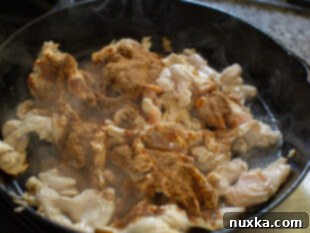 chicken strips cooking with fajita seasoning in a skillet