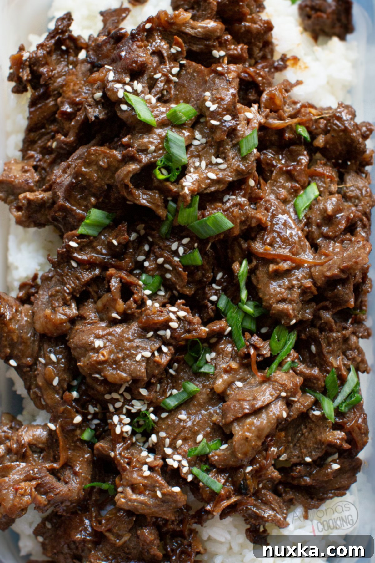 Korean beef Bulgogi over rice, garnished with sesame seeds and green onions