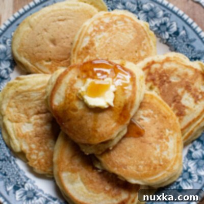 Fluffy homemade pancake stack with berries and syrup