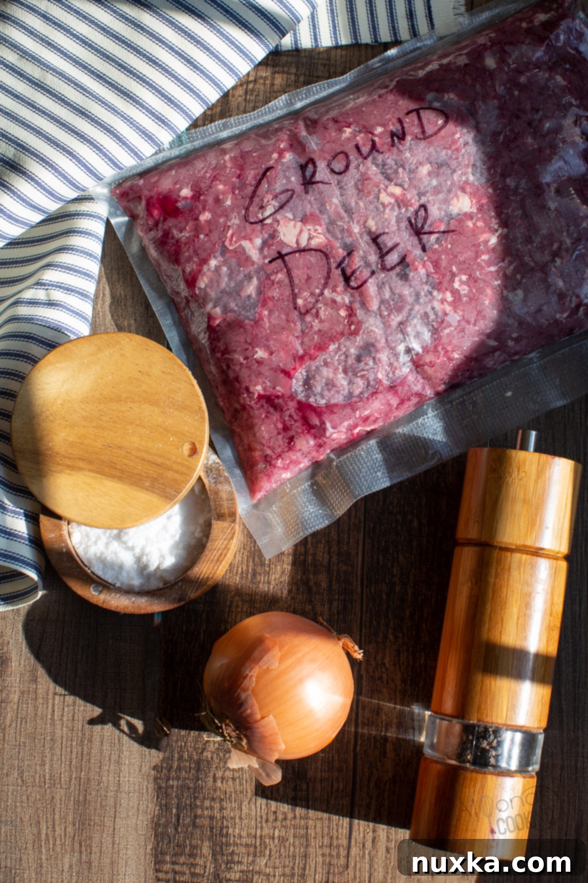 Fresh ingredients for venison burgers: ground venison, seasonings, and onion