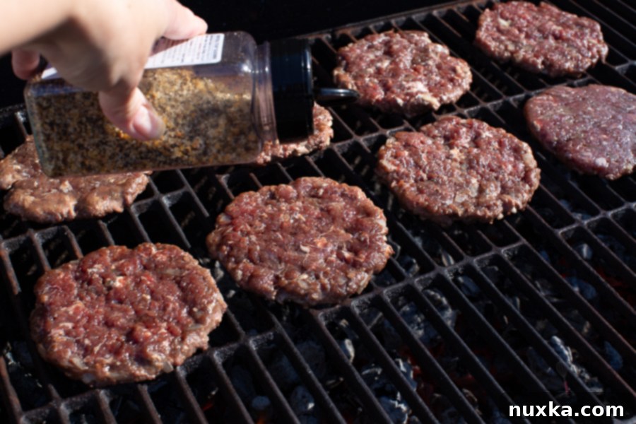 Close-up of venison burger patties being grilled, showcasing the technique for juicy results