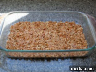 Pressing pretzel mixture into a baking dish