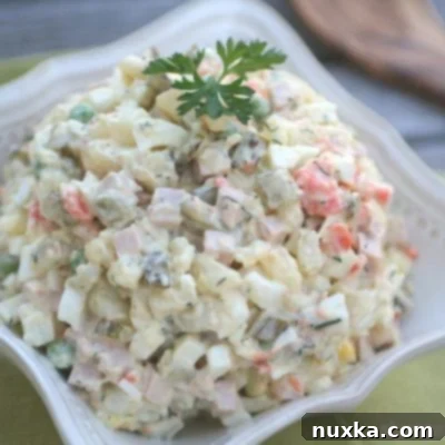 A close-up image of the classic Olivye Salad, a creamy, savory potato salad beloved in Slavic cuisine, perfect for holidays.
