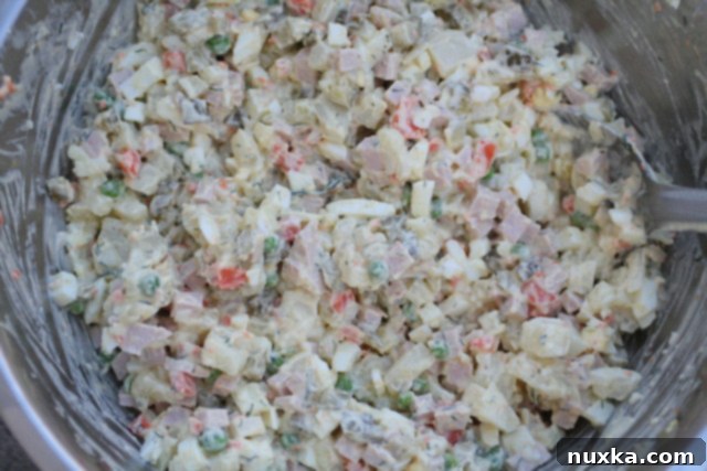 A serving of finished Olivye Salad, garnished and ready for enjoyment.