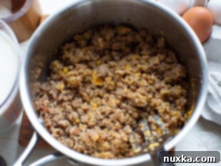 Fried breakfast sausage in a skillet, ready for casserole assembly.