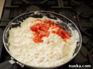 Mixing shrimp, cheeses, garlic, and seasonings into the creamy filling for stuffed shells.