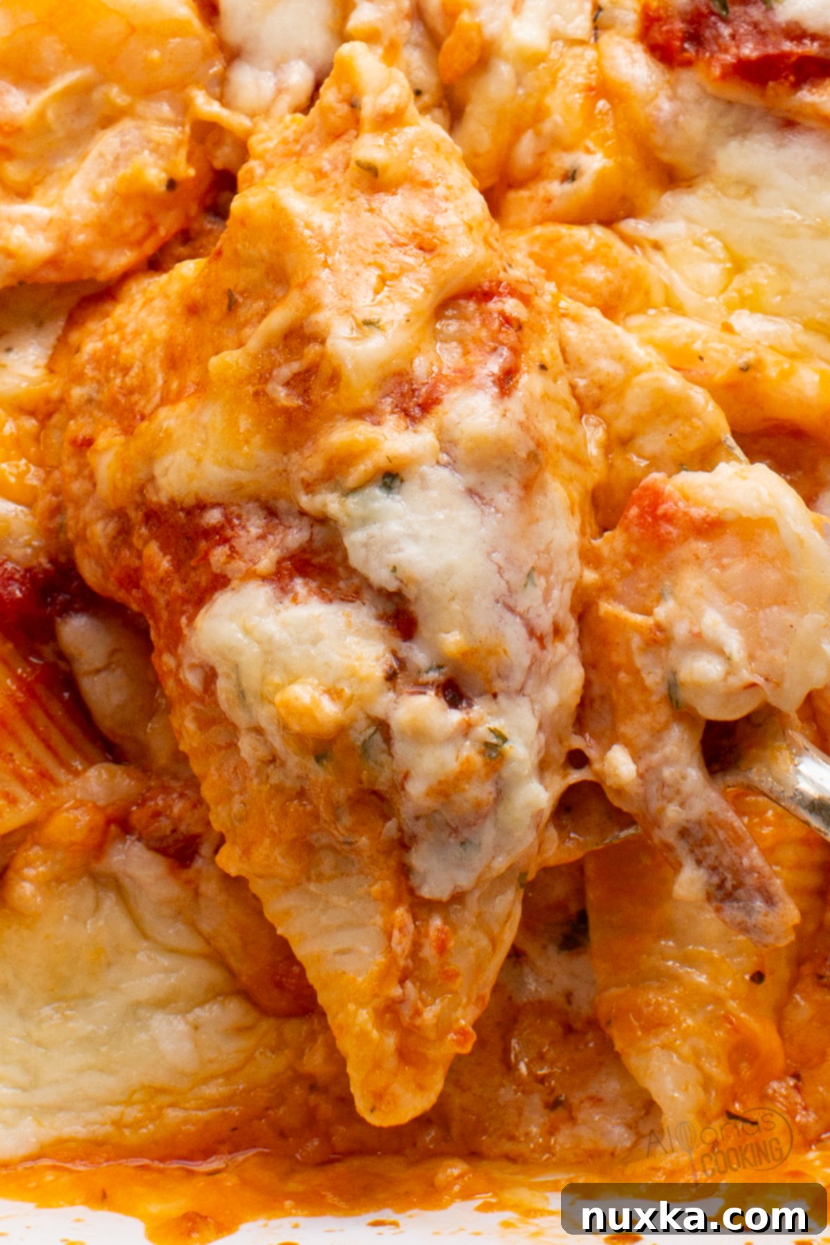 Jumbo pasta shells filled with a creamy shrimp and cheese mixture, arranged in a baking dish before sauce is added.