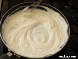 Melting cream cheese, heavy cream, mayonnaise, and olive oil in a non-stick skillet for shrimp stuffed shells filling.