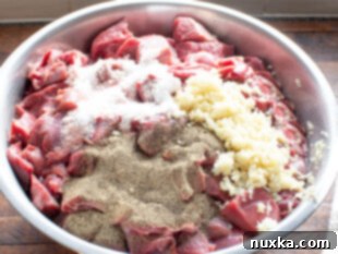 Cubed meat seasoned with garlic, salt, and pepper.