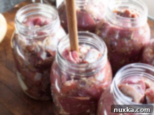 Jars packed with seasoned meat up to the headspace.