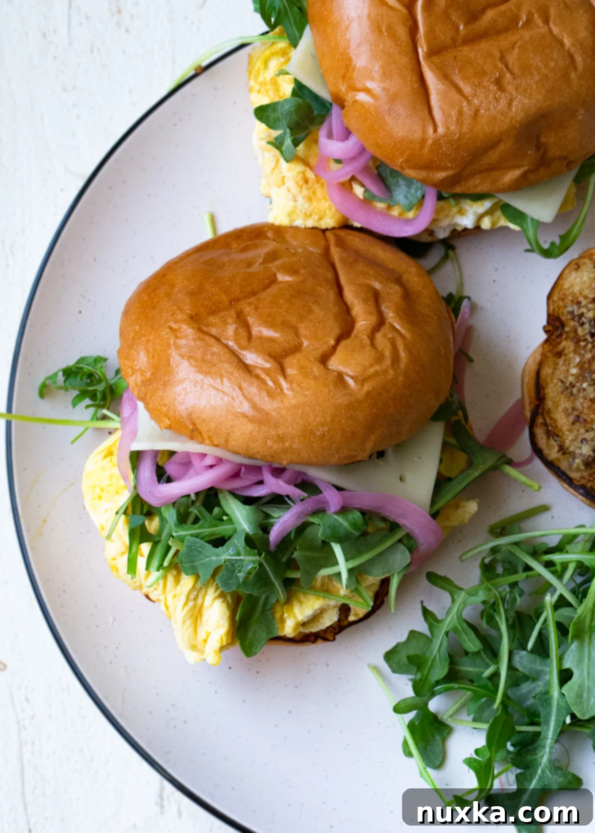 Best Bistro-style Egg Sandwich with fluffy scrambled eggs, vibrant Calabrian mayo, and crunchy pickled red onions on a toasted brioche bun