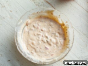 Calabrian mayo (mayonnaise with Italian cherry peppers) being whisked in a bowl for the egg sandwich