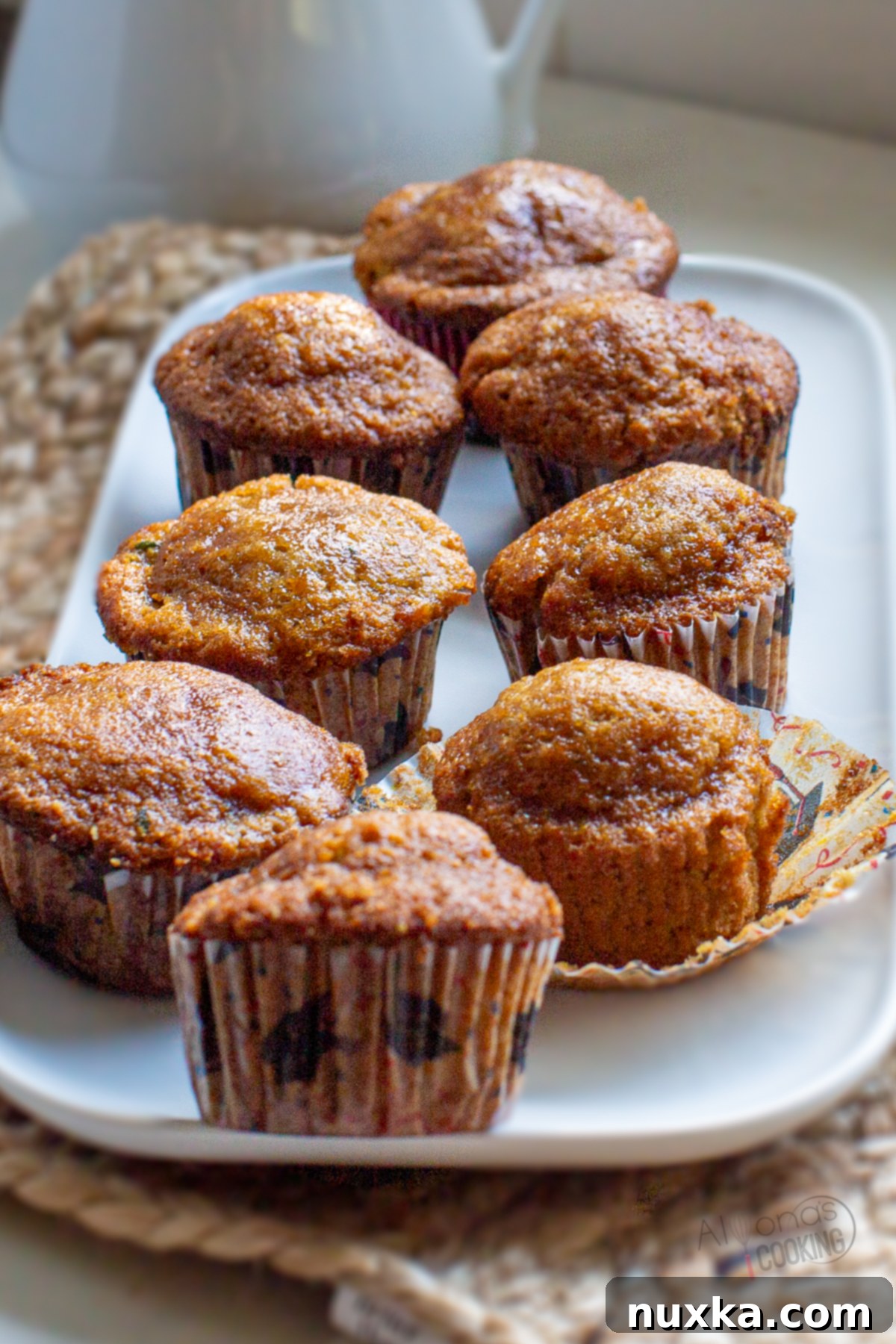 A close-up of a stack of golden brown zucchini muffins
