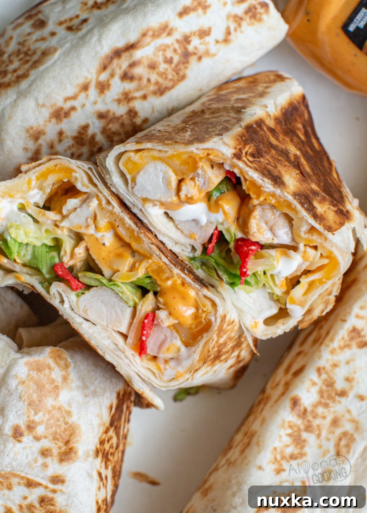 Chipotle Ranch Grilled Chicken Burrito is a Taco Bell Burrito stuffed with grilled chicken, crunchy tortilla strips, lettuce, tomatoes, cheese, and creamy chipotle and ranch sauce. This copycat burrito recipe has become a family favorite Mexican meal that is quick and easy to make! Kids, even love these warm flour tortillas wrapped around these tasty taco toppings!
