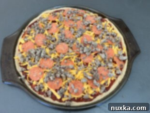 cooked sausage and pepperoni pizza, sliced and ready to serve
