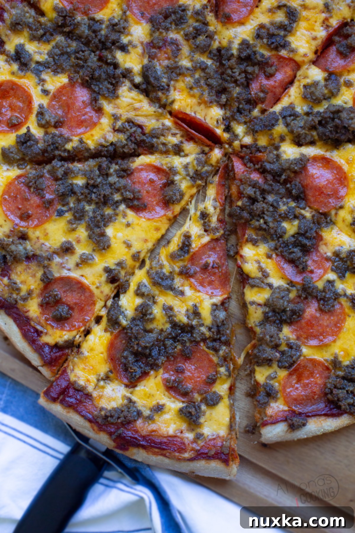 whole wheat pizza dough from freshly milled flour, generously topped with cheese, sausage, and pepperoni