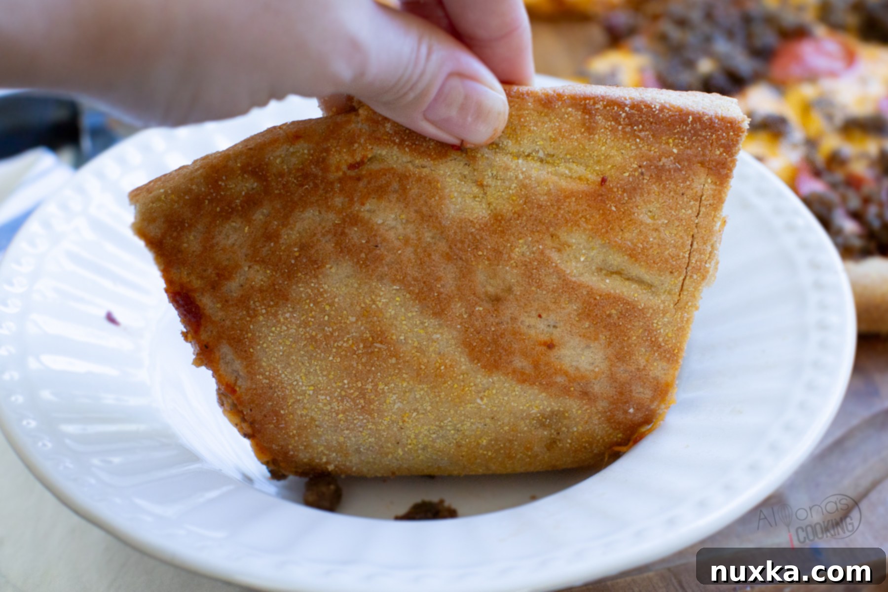 crispy whole wheat pizza dough slice, showing off its golden, airy texture