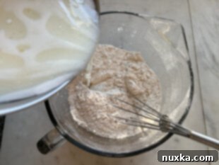 Adding wet ingredients to dry ingredients for whole wheat waffle batter