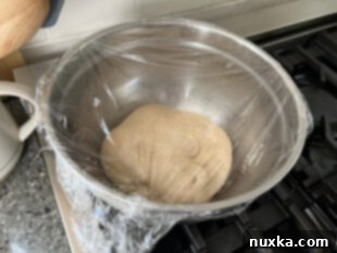 Sourdough bagel dough fermenting in a covered bowl