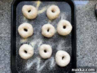 Sourdough bagels rising on a baking tray