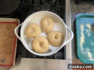 Boiling bagels in a large pot on the stove