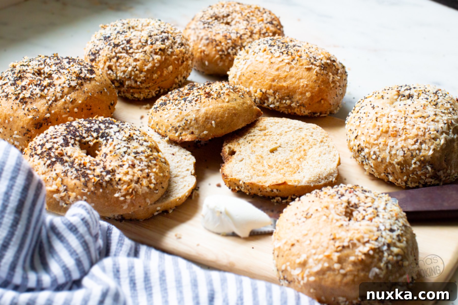 Sliced whole wheat sourdough bagels on a cutting board, ready to be topped.