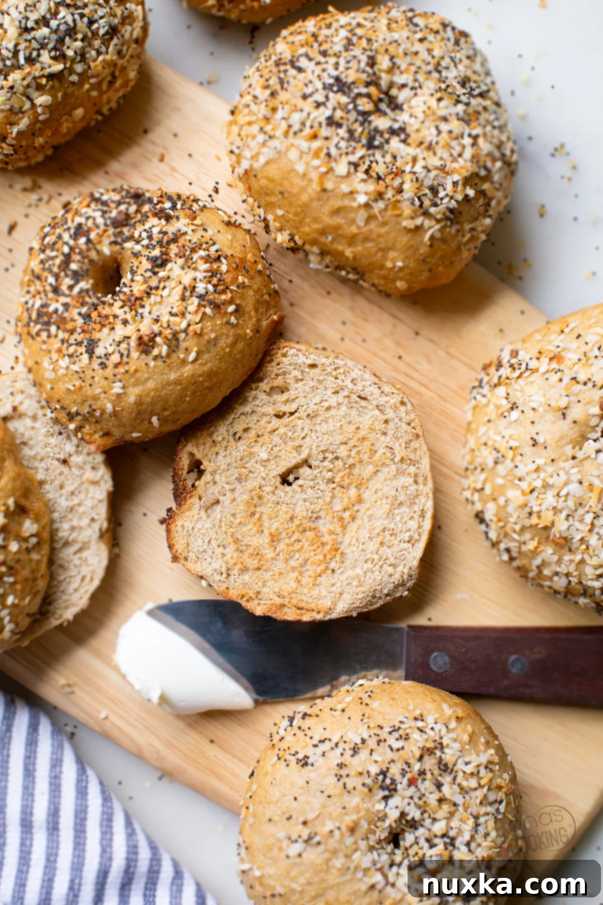 A perfectly sliced whole wheat sourdough bagel revealing its soft, chewy interior.