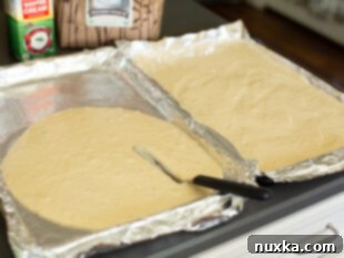 spreading honey cake batter onto jelly roll pans