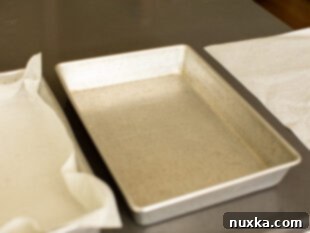 Cake pans lined with parchment paper, ready for batter