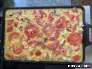 topping the frittata with, cheese and tomatoes for baking