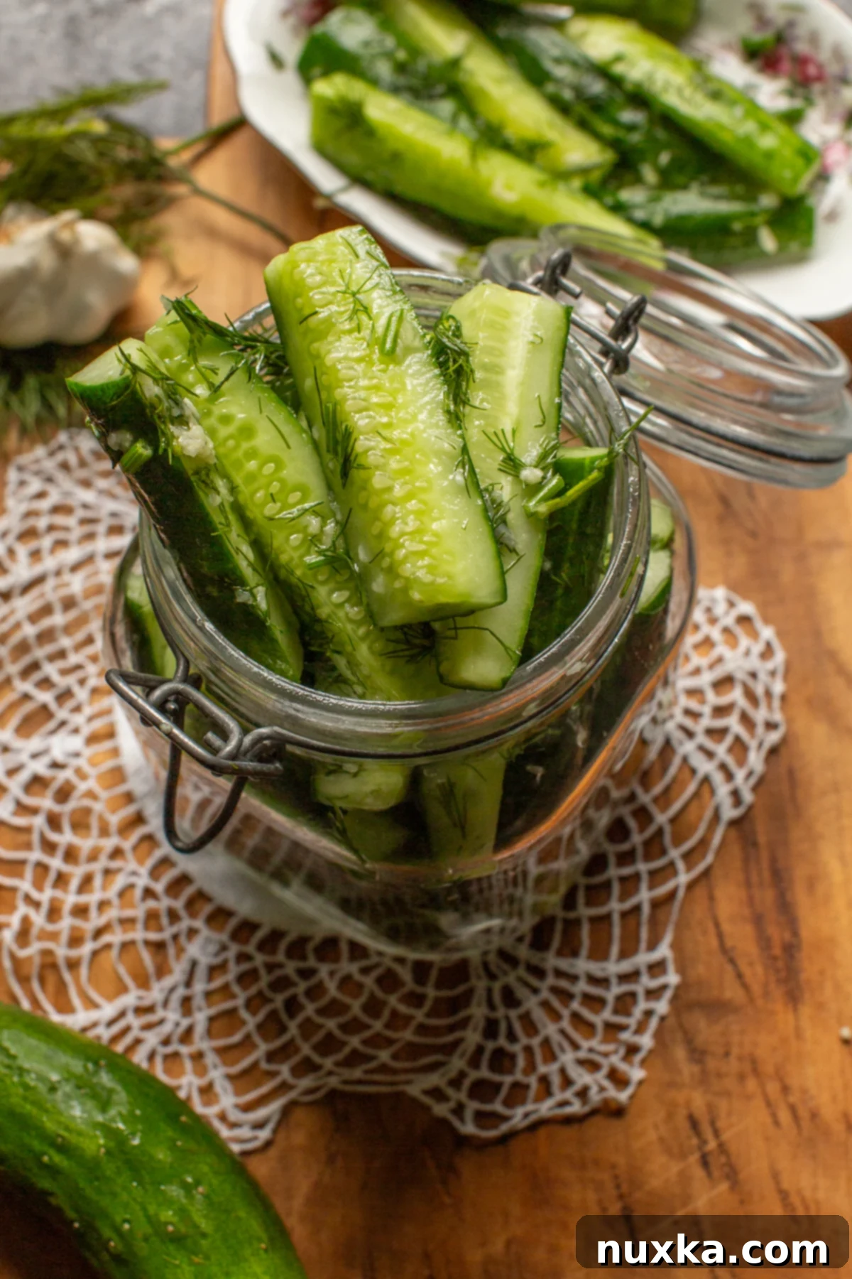 Freshly cut garlic and dill marinated cucumbers in a bowl