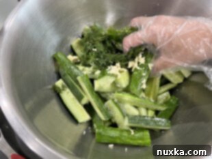 marinating cucumbers in a large bowl with dill and garlic