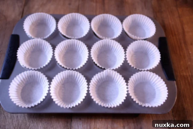 Muffin tin lined with paper baking cups, ready for banana muffin batter
