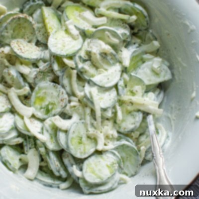 Refreshing Creamy Cucumber & Onion Medley 4 cucumber onion salad in a white enamal bowl